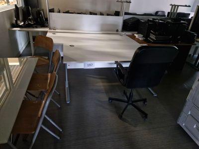 une pièce équipée d'un bureau, de chaises et d'un réfrigérateur