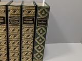 a set of five books sitting on top of a white table