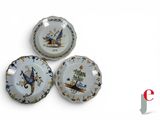three plates with birds painted on them on a white surface