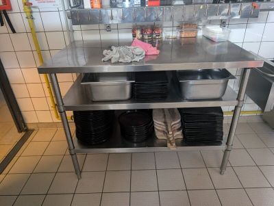 a stainless steel table in a restaurant kitchen with dishes on it