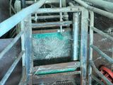 a metal gate that has a green bucket in it
