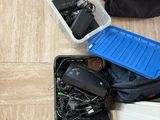 a person sitting on the floor next to a suitcase full of electronics