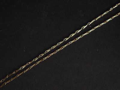un gros plan d'un collier avec une chaîne en or sur fond noir
