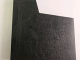 a close up of a piece of black paper on a white surface