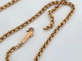 a close up of a gold chain on a white surface