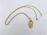 a gold necklace with a face of jesus on it