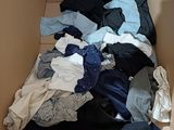 a box full of clothes that is sitting on the floor