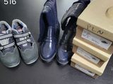 Plusieurs paires de chaussures d'enfants sont alignées à côté d'une boîte en carton