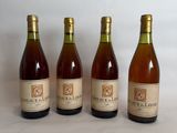 four bottles of wine are lined up on a white surface