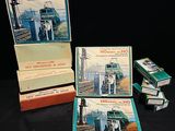 Plusieurs cartons remplis de livres sont empilés les uns sur les autres sur une surface noire.