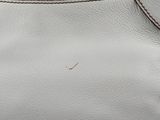 a close up of a white purse with a zipper on it