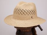 un chapeau de paille posé sur un support en bois