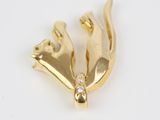 a close up of a gold bird brooch on a white background