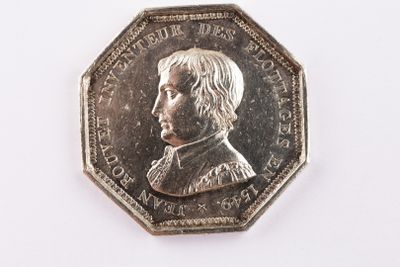 une pièce d'argent sur laquelle figure l'image d'un homme
