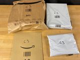 trois sacs de produits amazon posés sur une table en bois