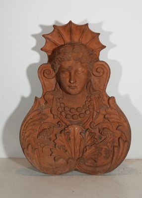 une photo d'une sculpture en argile représentant le visage d'une femme, posée sur une étagère