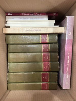 many books in a box that are stacked together