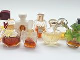 many different bottles of perfume on a white surface