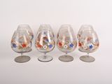 quatre verres à vin décorés de fleurs, disposés les uns à côté des autres