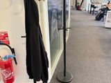 a coat rack with an umbrella on it next to a fire extinguisor