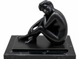 statue of a man sitting on a black marble base