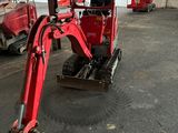 une photo d'une petite pelleteuse rouge dans un garage