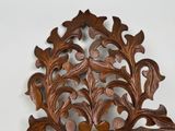 a wooden carving of a leaf and flower design on the wall