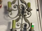 a wall mounted candle holder with two green candles