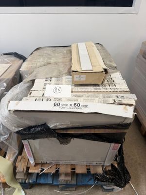 a pile of boxes sitting on a pallet in the middle of a room