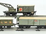 three toy trains on the tracks with a crane on top of them