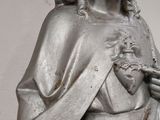 a statue of jesus holding a bird in his hand