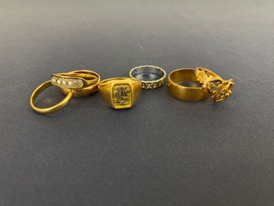 trois anneaux en or et deux anneaux en argent sur un fond noir