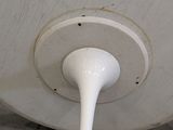 a white ceiling fan sitting on the floor in a room