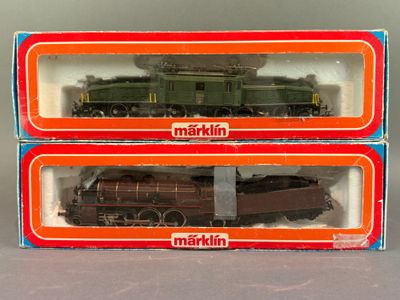 deux boîtes contenant des trains miniatures, posées l'une à côté de l'autre sur une table
