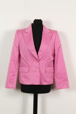 un blazer rose posé sur un mannequin contre un mur blanc