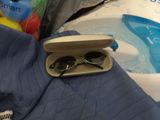 a pair of sunglasses sitting in a case on a bed