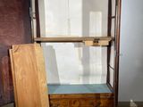 a wooden cabinet with a glass door in the corner of the room