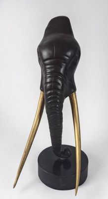 statue of an elephant with tusks on a black base