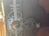 a cross on the door handle of a wooden door