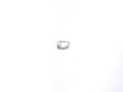 un petit diamant blanc posé sur une surface blanche