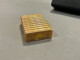 a gold lighter sitting on a table next to a keyboard