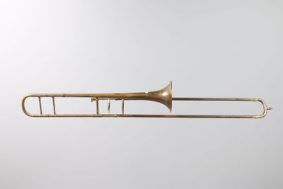 an old brass trombone with a white background