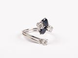 un gros plan d'une bague sertie d'un saphir bleu et de diamants blancs