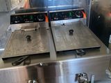 two deep fryers sitting on top of a stove