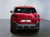 the rear end of a red citrole parked in a white room