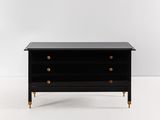 une commode noire avec des poignées en laiton et un plateau noir