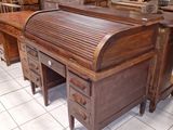 un bureau en bois à abattant et à tiroirs, dans une pièce