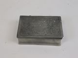 une vieille boîte en argent posée sur une table blanche
