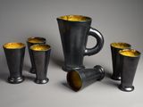 quatre tasses et un pichet posés sur une table