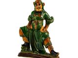 une figurine d'un homme assis sur un banc